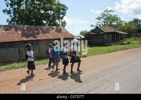 Madagascar, Malagasy Children walking in the street coming from school Nosy Be island, Hell Ville city geography Africa. Stock Photo