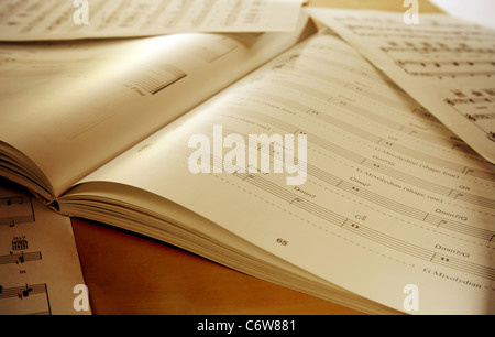 Book and papers with music notes on table Stock Photo