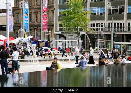 People relaxing by the water feature in the Old Market Square Nottingham England UK Stock Photo