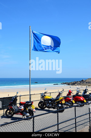 The Blue flag ( awarded for beach cleanliness ) flys over Porthmeor beach in St.Ives, Cornwall, UK Stock Photo