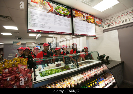 Employees wait to greet hungry customers at the Earl of Sandwich opening of their first shop in New York Stock Photo