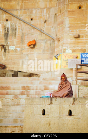 A man meditates on the banks of the Ganges River in the Hindu holy city of Varanasi, India in Uttar Pradesh state Stock Photo