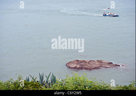 A boat with Chinese tourists just off the Taiwan coast at Mashan Observation Post, Kinmen, Taiwan Stock Photo