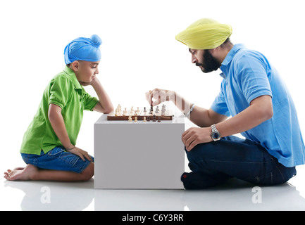 Sikh boy playing chess with his dad Stock Photo