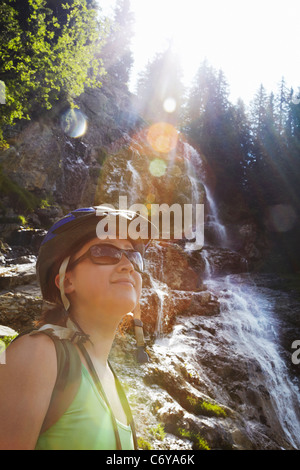 Hiker admiring landscape on hillside Stock Photo