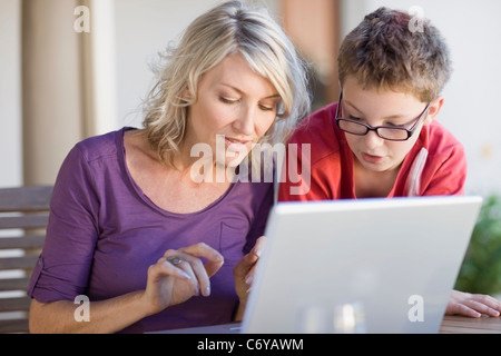 Mother and son using laptop together Stock Photo
