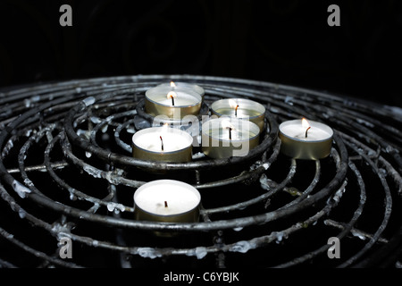 Offertory or Prayer Candles burning in remembrance of loved ones in a Catholic church. Stock Photo