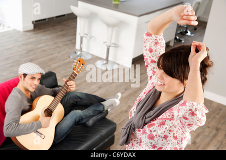 Woman dancing as boyfriend plays music Stock Photo