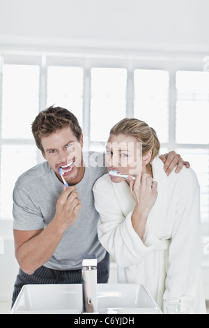 Couple brushing their teeth in bathroom Stock Photo