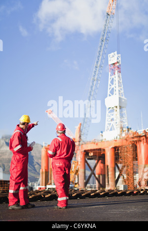 Workers talking on oil rig Stock Photo