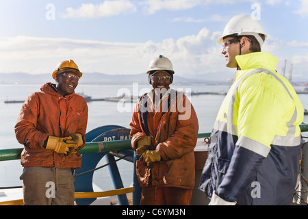 Workers talking on oil rig Stock Photo