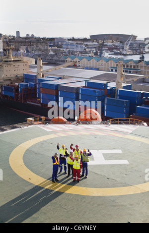 Workers talking on helipad of oil rig Stock Photo