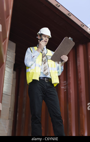 Worker using walkie talkie in container Stock Photo