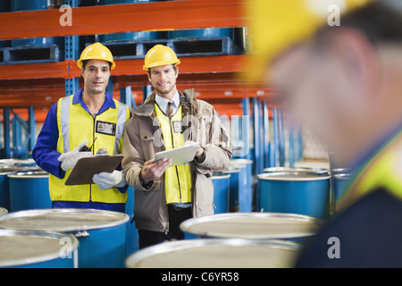 Workers reading clipboards in warehouse Stock Photo
