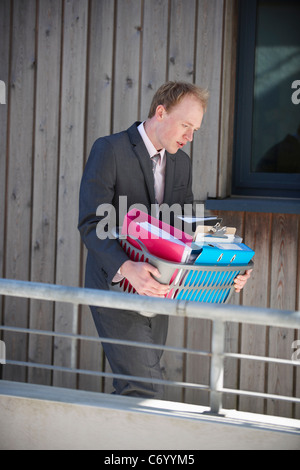 Businessman carrying box of supplies Stock Photo