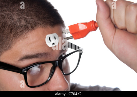 Conceptual image of a young man holding an electrical chord unplugged from the outlet on his forehead. Stock Photo