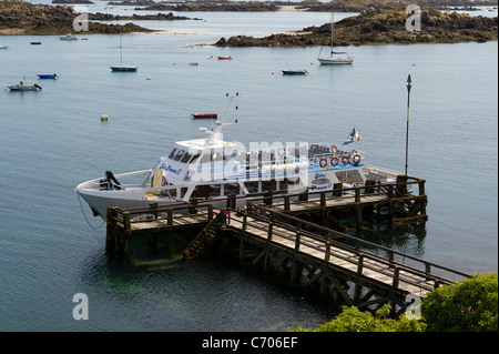 Tourist boat Jolie France II moored alongside jetty at high tide on Grande Ile in the Iles Chausey. Stock Photo