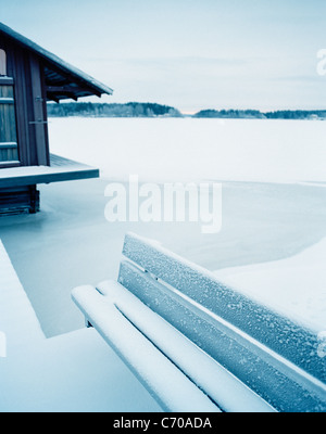 Snow covered bench and field Stock Photo