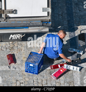 Man replacing the damaged tail lights on a lorry trailer. View from the rear behind. Close up