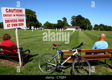 Sign warning drivers that they park next to the cricket ground at their own risk while a match is in progress, Southborough Common, Kent, England Stock Photo