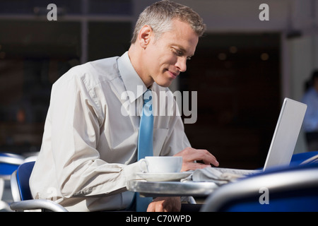Businessman using laptop at cafe Stock Photo