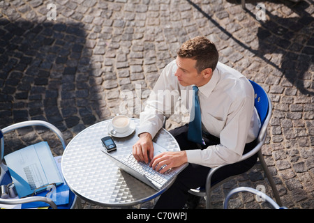 Businessman using laptop at cafe Stock Photo