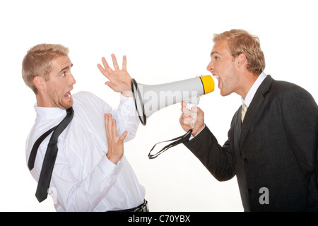 angry boss in suit yelling into a megaphone to scared employee - isolated on white Stock Photo