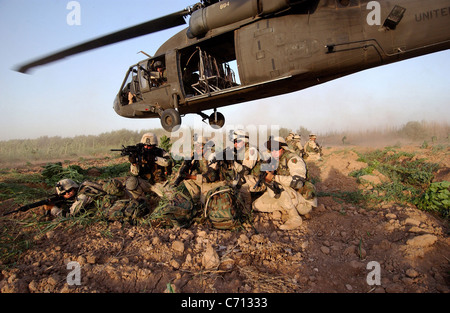 Members of Bravo Section, 2nd Brigade Recon Troop, brace themselves in a security posture after being infiltrated by a UH-60A Black Hawk helicopter during a Quick Response Force Weapons Interdiction mission in Iraq on June 19, 2004. The Quick Response Force responds to immediate action situations directed by the Tactical Operations Center commander. DoD photo by Tech. Sgt. Scott Reed, U.S. Air Force. (Released) Stock Photo