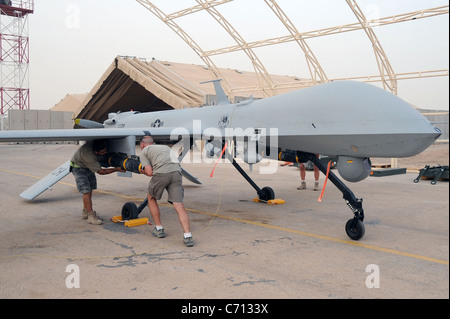 Shilo Thompson and Brandon Walker, both aircraft mechanics with the 361st Expeditionary Reconnaissance Squadron, load an AFM-114 Hellfire missile onto an MQ-1B Predator unmanned aerial vehicle at Ali Air Base, Iraq, on July 9, 2008. The Predator provides integrated and synchronized close air combat operations for intelligence, surveillance and reconnaissance purposes. DoD photo by Tech. Sgt. Sabrina Johnson, U.S. Air Force. (Released) Stock Photo