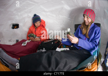 Boy and girl playing cards in snow cave, Silverton, Colorado. Stock Photo