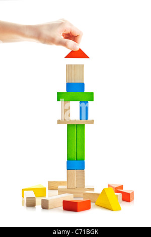 Hand building tower of wooden blocks isolated on white background Stock Photo