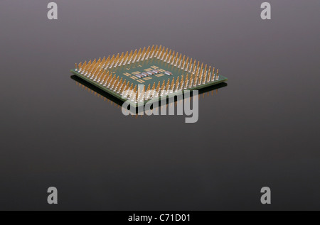A CPU chip on a reflective black surface. Stock Photo