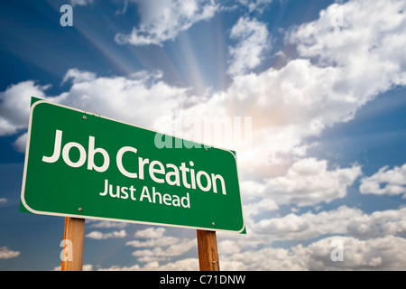 Job Creation Green Road Sign Against Dramatic Sky, Clouds and Sunburst. Stock Photo