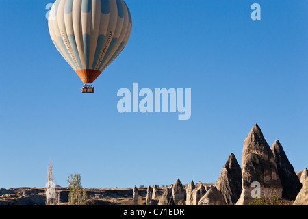 Kapadokya Balloons above the needles. A full basket below a hot air balloon set in bright blue morning sky over Goreme's hoodos Stock Photo