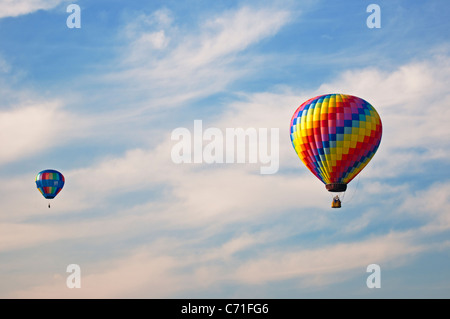 A hot air balloon festival in Bealeton, Virginia / Two hot air balloons flying with a hazy blue sky background Stock Photo
