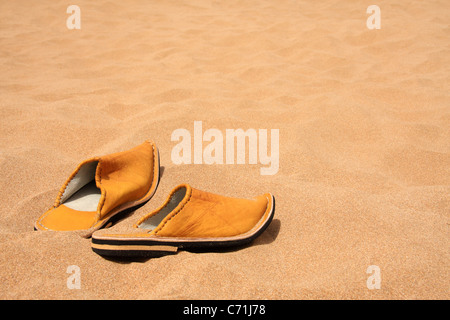Traditional Moroccan slippers shoes (babouches) on a beach in Morocco with copy space, Morocco, North Africa Stock Photo