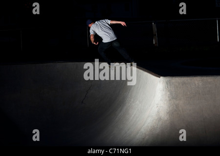 A happy athletic man skateboards at night in Idaho. Stock Photo