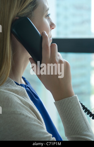 Woman talking on landline phone Stock Photo