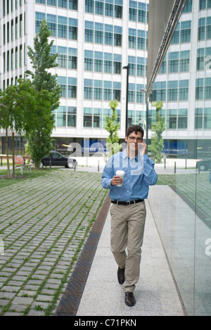 Man talking on cell phone while walking in city Stock Photo