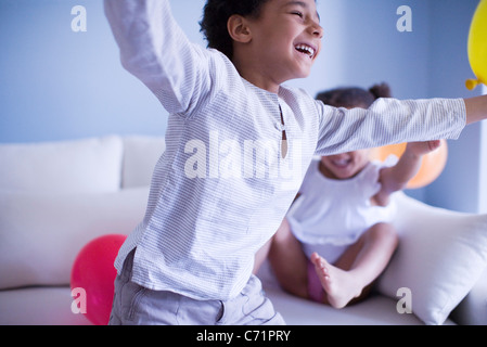Young boy and little sister playing with balloons Stock Photo