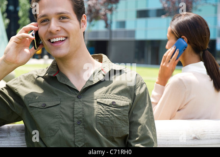 Man talking on cell phone outdoors with cheerful expression Stock Photo