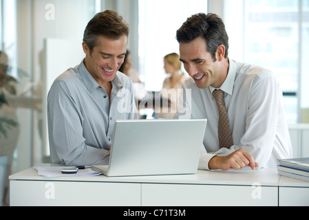 Executives working together on laptop computer Stock Photo