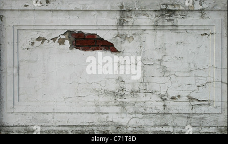 damaged plastered cracked brick wall section for background texture Stock Photo