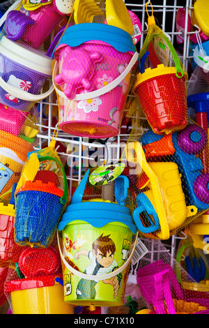 Brightly coloured children's plastic beach toys on display outside a seaside shop. Stock Photo