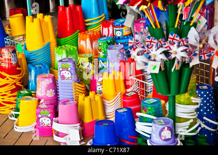 Brightly coloured children's plastic beach toys and buckets on display outside a seaside shop. Stock Photo