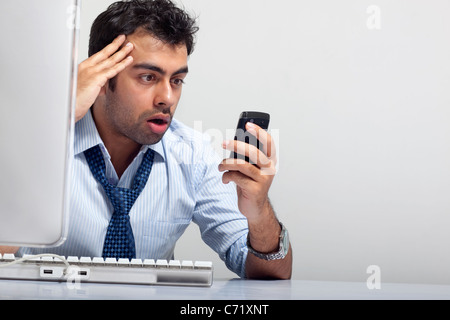 Businessman getting stressed while reading an sms Stock Photo