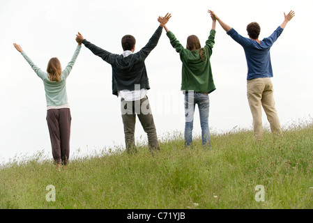 Friends holding hands, rear view Stock Photo