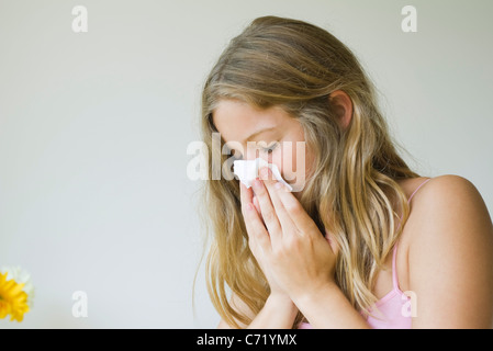 Young woman blowing her nose Stock Photo