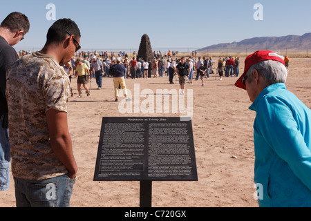 Sightseers read a sign at Trinity Site describing radiation at the the site of the world's first atomic bomb test in 1945. New Mexico, USA. Stock Photo