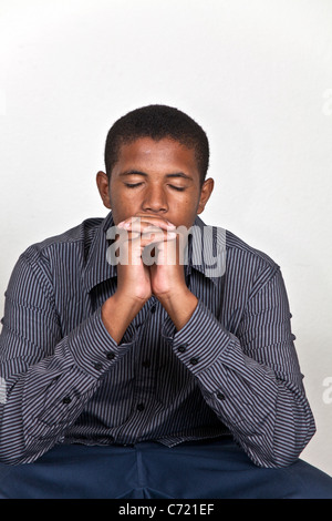 Teen boy meditating,child praying hands clasped head bowed. MR ...